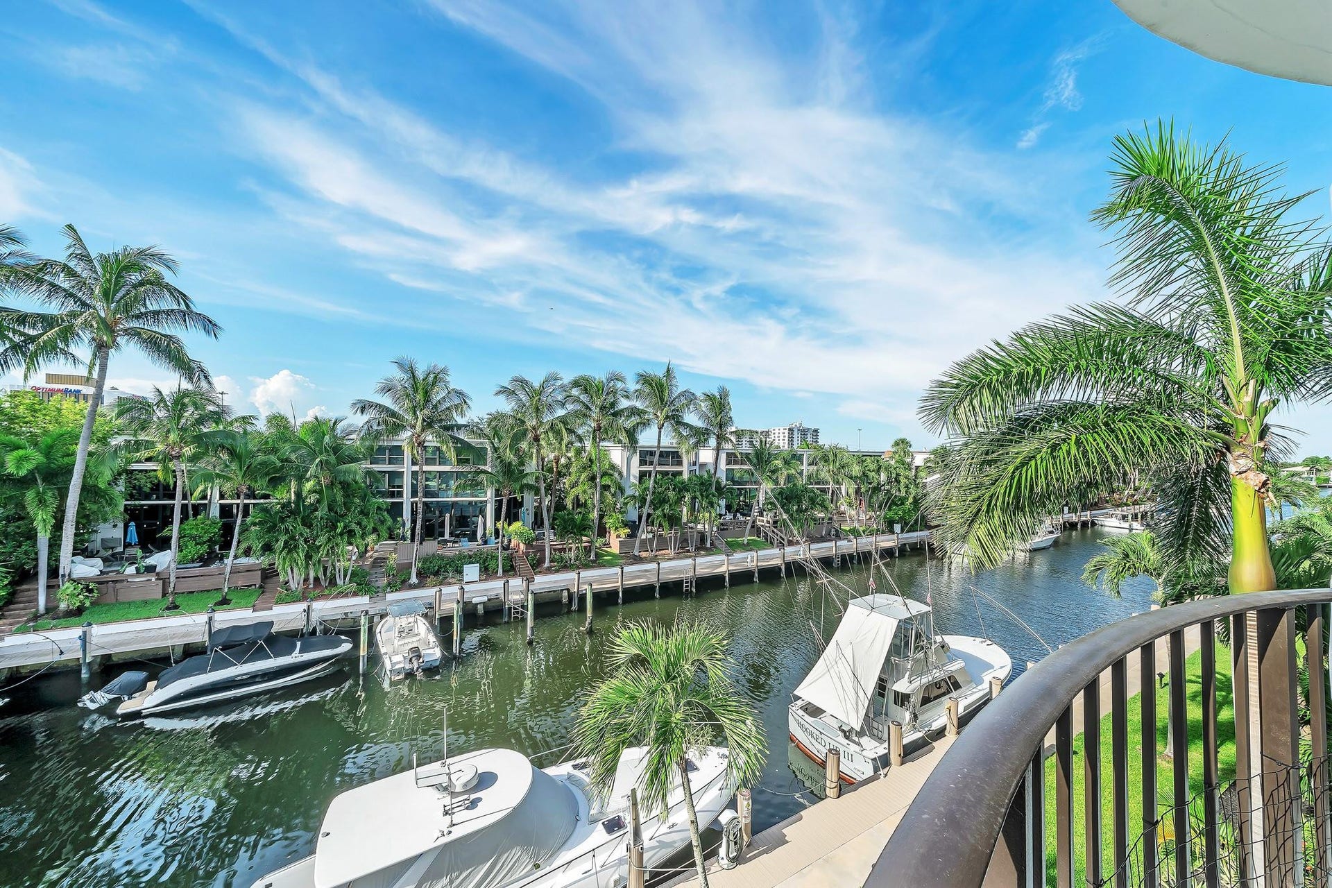 3051 NE 48TH Street, #301, Fort Lauderdale, Fort Lauderdale, FL 33308 Waterfront property featuring a private dock, lush palm trees, and canal access