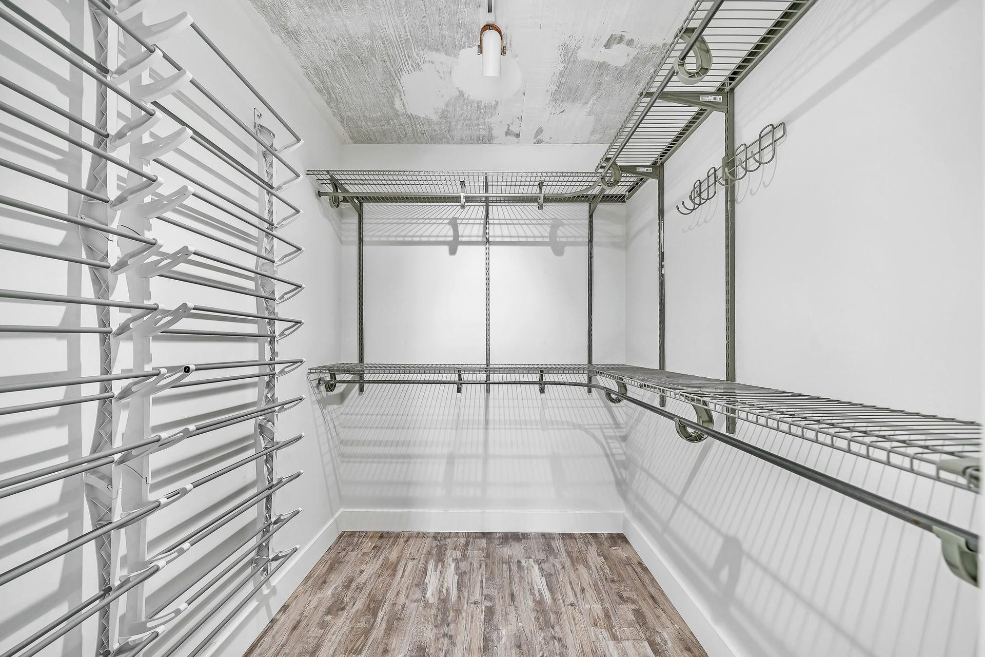 3051 NE 48TH Street, #301, Fort Lauderdale, Fort Lauderdale, FL 33308 Walk-in closet featuring wood-finish flooring, white walls, built-in wire shelving, and multiple hanging rods