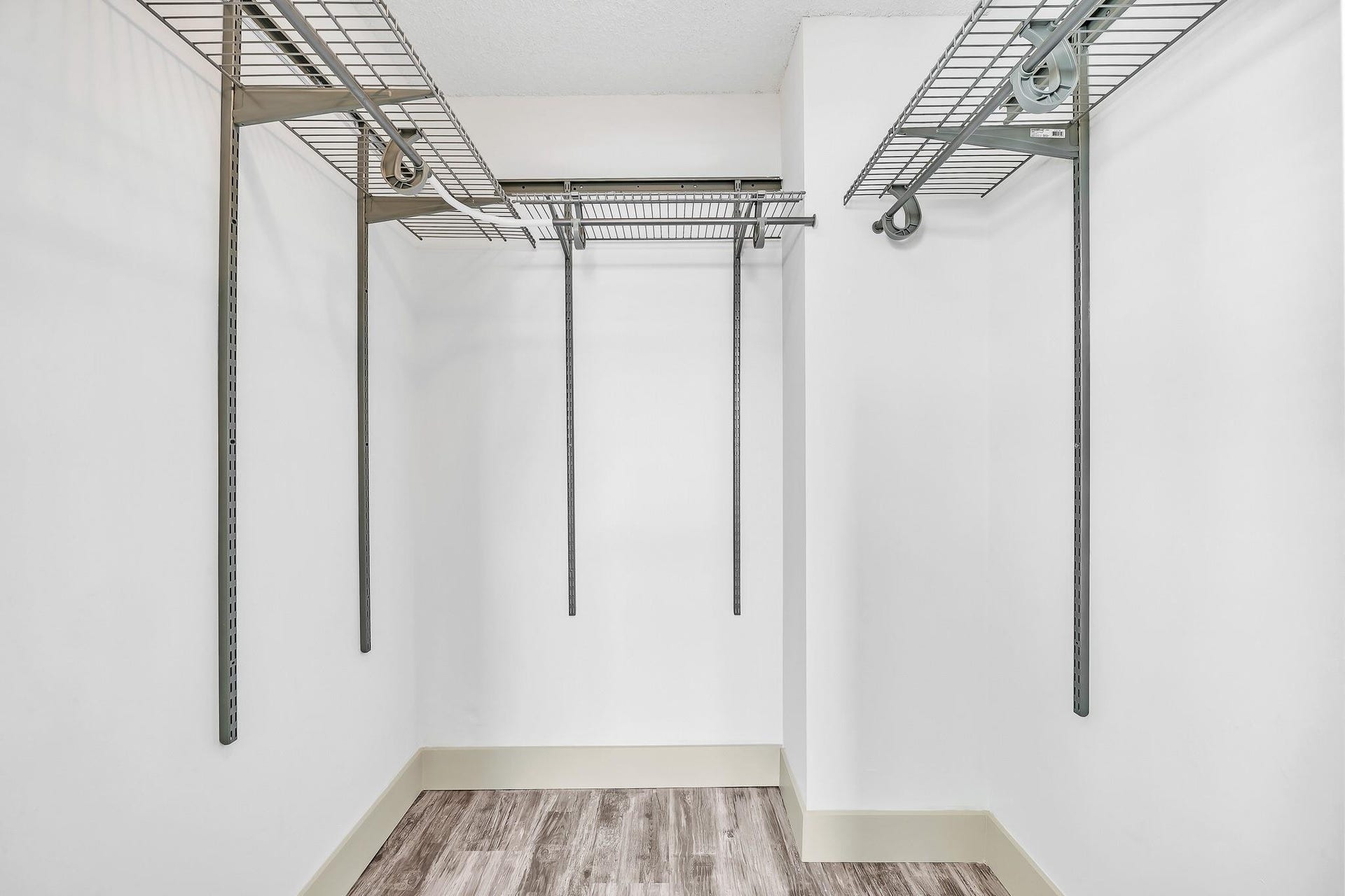 3051 NE 48TH Street, #301, Fort Lauderdale, Fort Lauderdale, FL 33308 Built-in wire shelving, adjustable hanging rods, white walls, wood-finish flooring, and light-colored baseboards