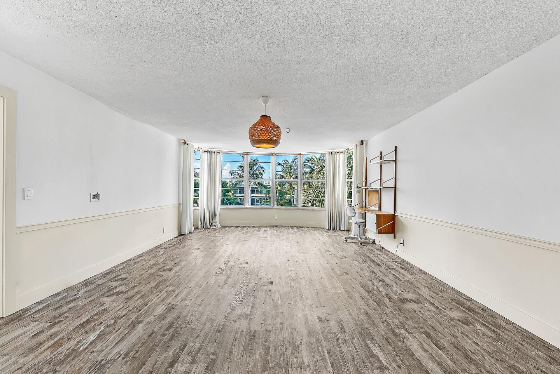 3051 NE 48TH Street, #301, Fort Lauderdale, Fort Lauderdale, FL 33308 Wood-finish flooring, half-wall wainscoting, and a curved window wall with multiple windows