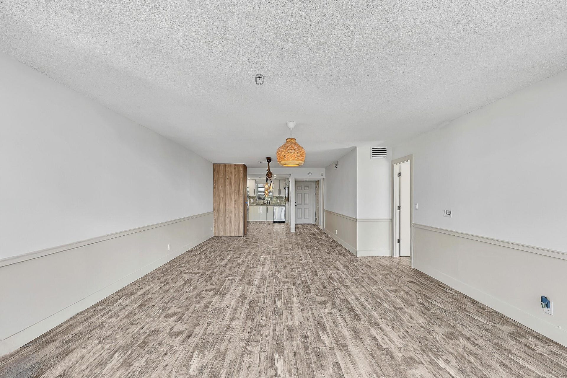 3051 NE 48TH Street, #301, Fort Lauderdale, Fort Lauderdale, FL 33308 Wood-finish flooring throughout, white walls with half-wall paneling, and two woven pendant light fixtures