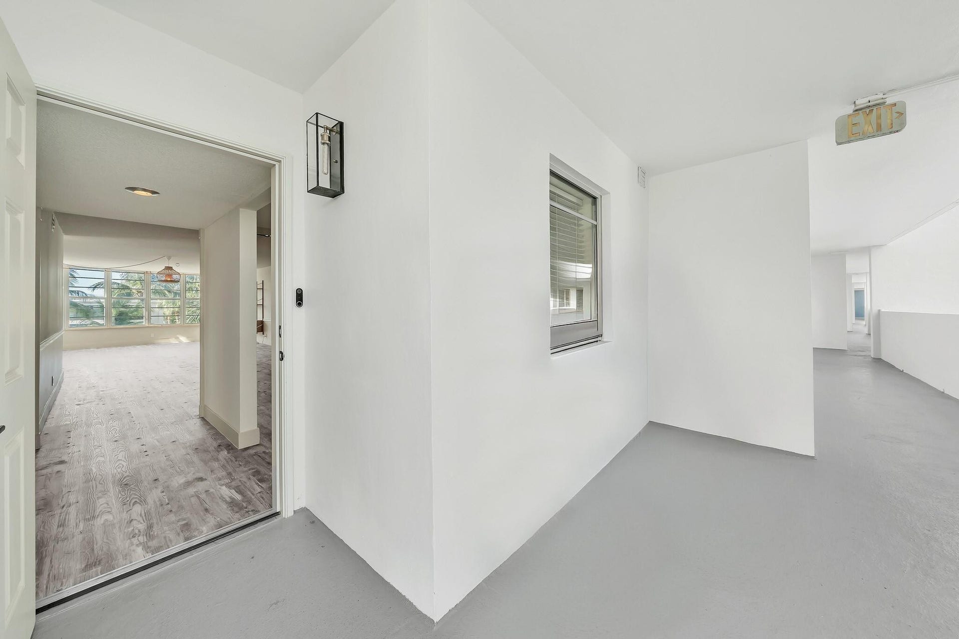 3051 NE 48TH Street, #301, Fort Lauderdale, Fort Lauderdale, FL 33308 Wood-finish flooring, white painted walls, and a contemporary wall sconce