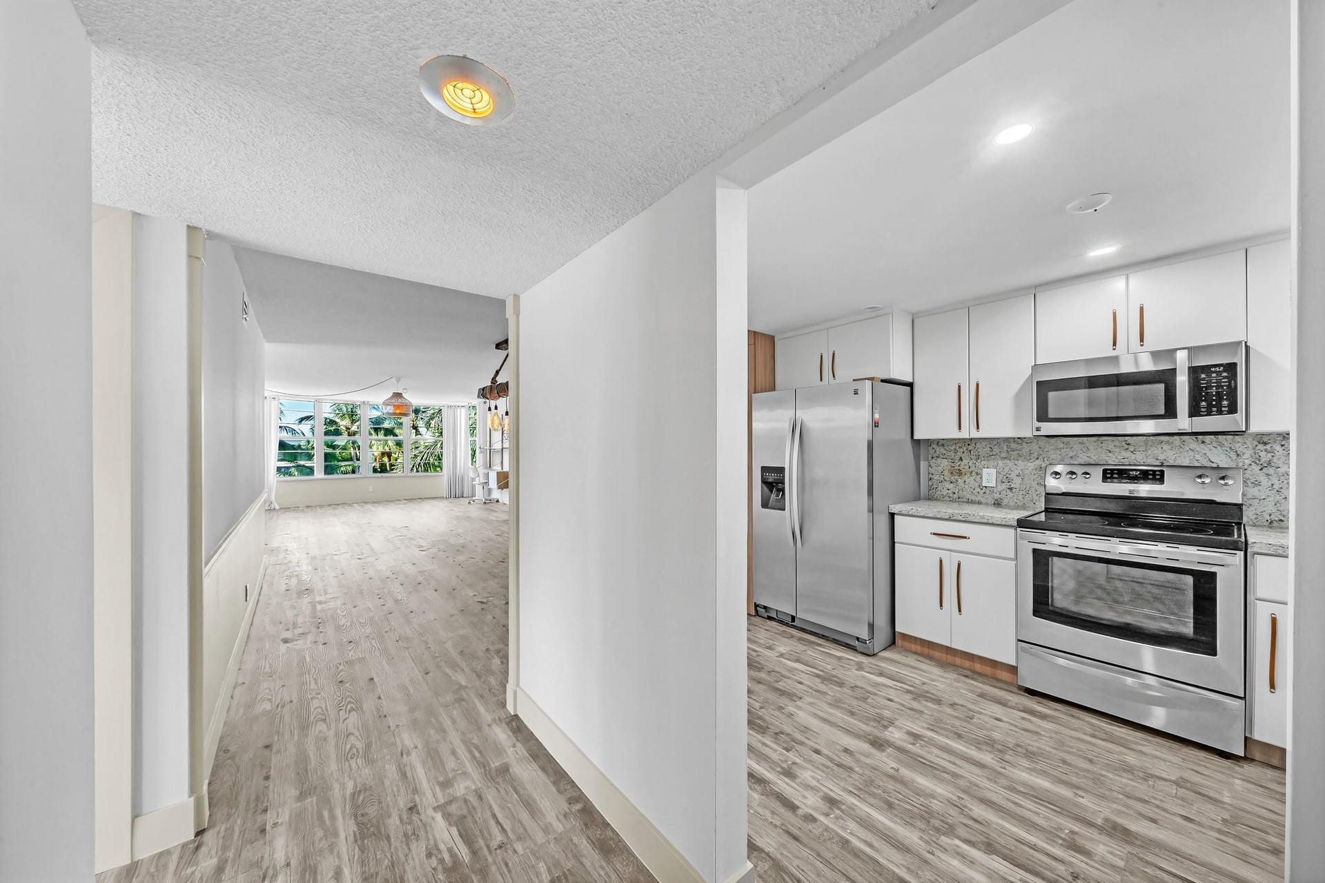 3051 NE 48TH Street, #301, Fort Lauderdale, Fort Lauderdale, FL 33308 Modern kitchen featuring stainless steel appliances, white cabinetry, and a light-toned backsplash
