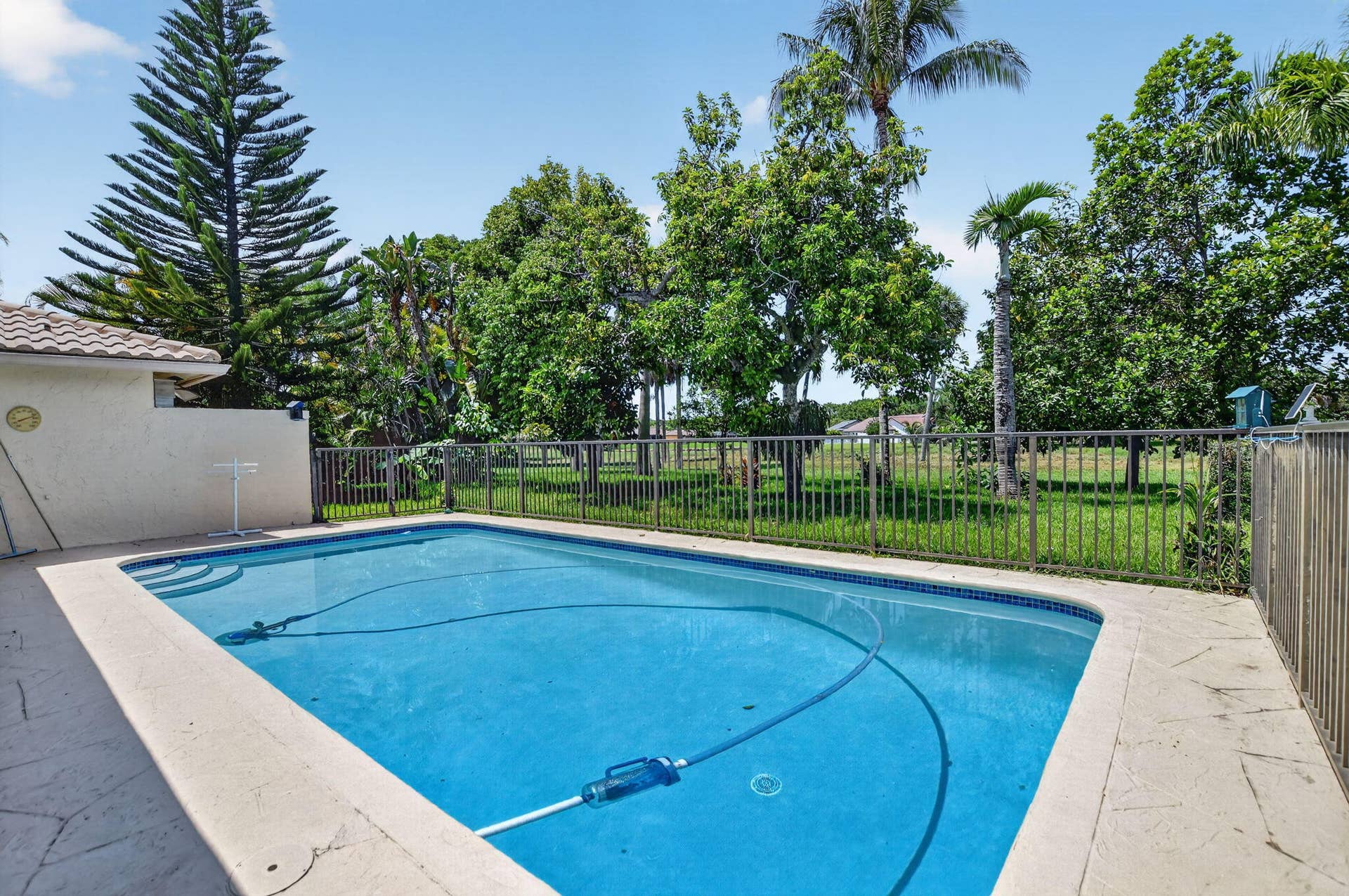 Rectangular swimming pool with integrated steps, surrounded by stamped concrete decking