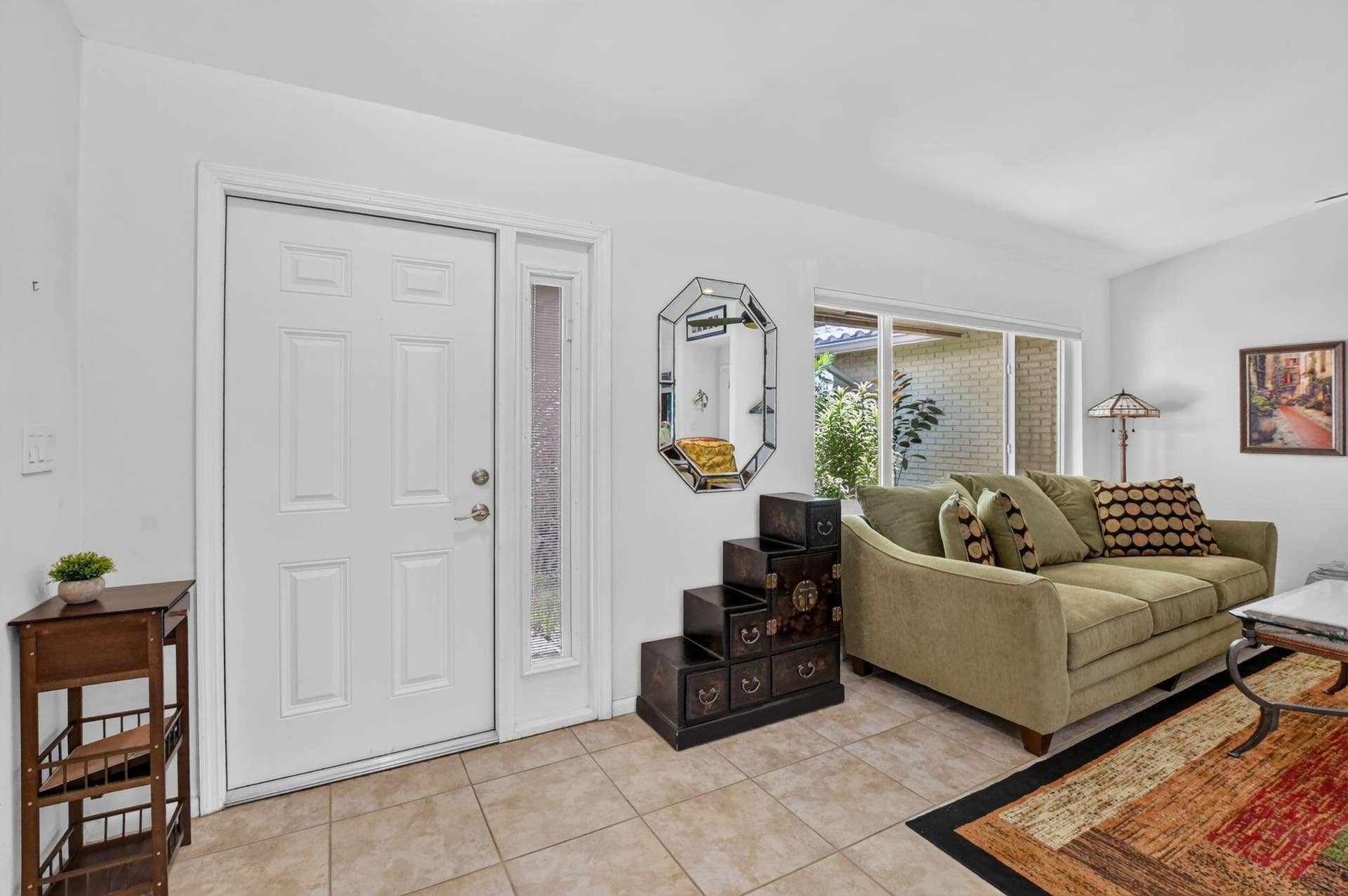Panel door with sidelight, tile flooring, and a large window
