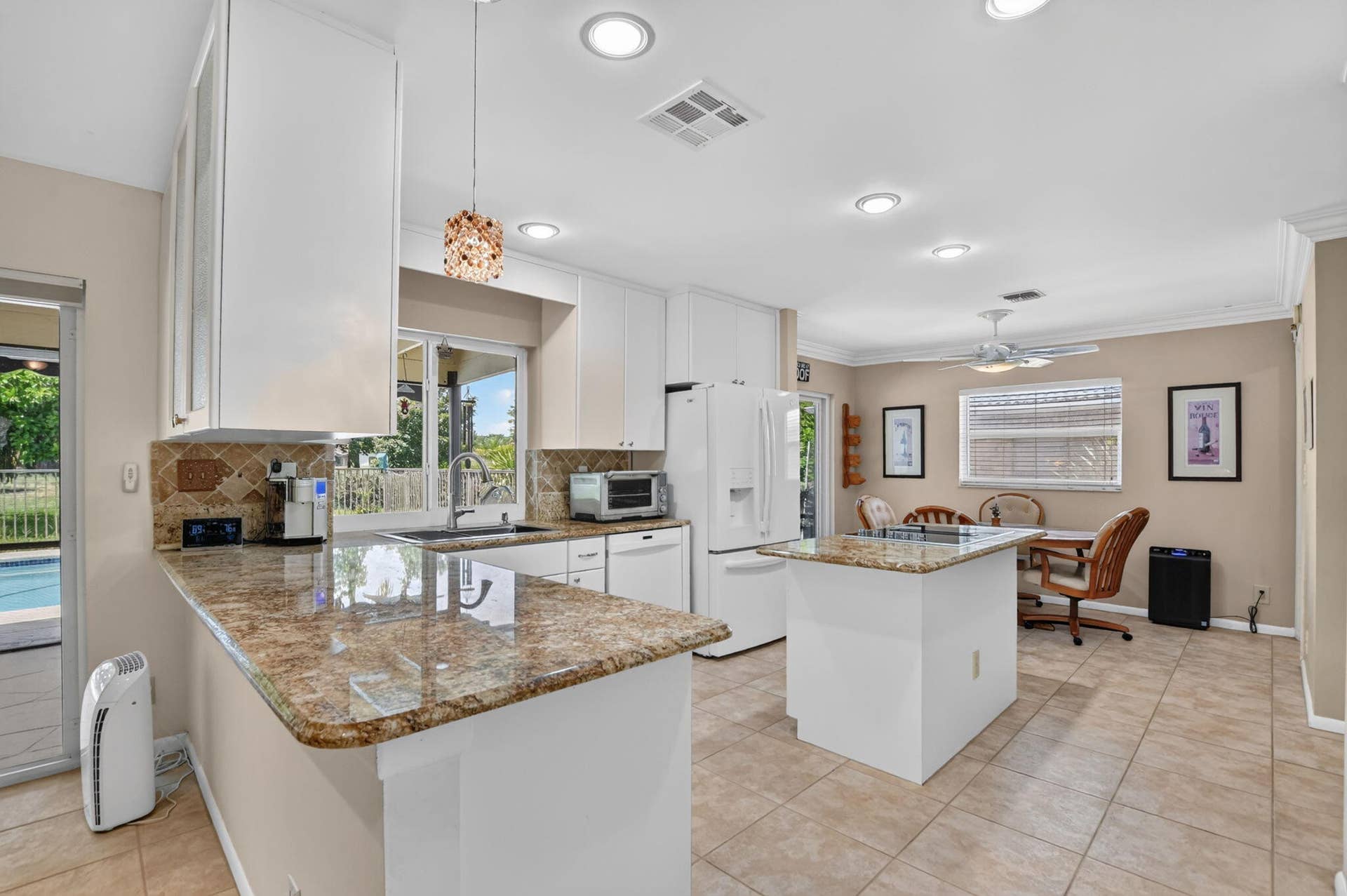 Kitchen featuring white cabinetry, granite countertops, tile backsplash, recessed lighting, and tile flooring