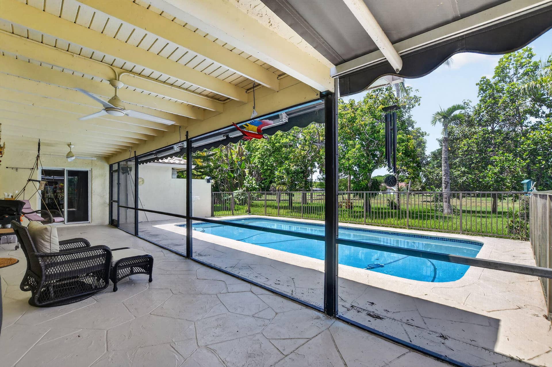Covered patio with a ceiling fan, screened enclosure, and an in-ground swimming pool