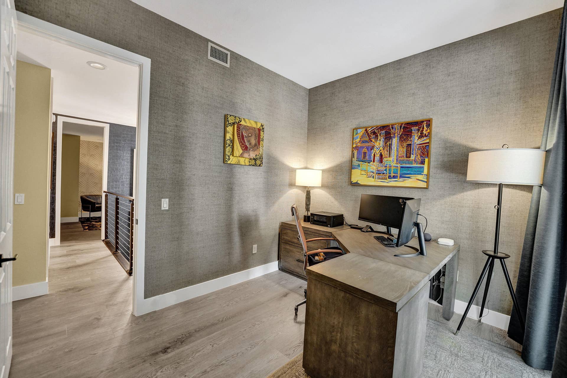 Neutral-toned walls with textured finish, light wood-finish flooring, and white trim