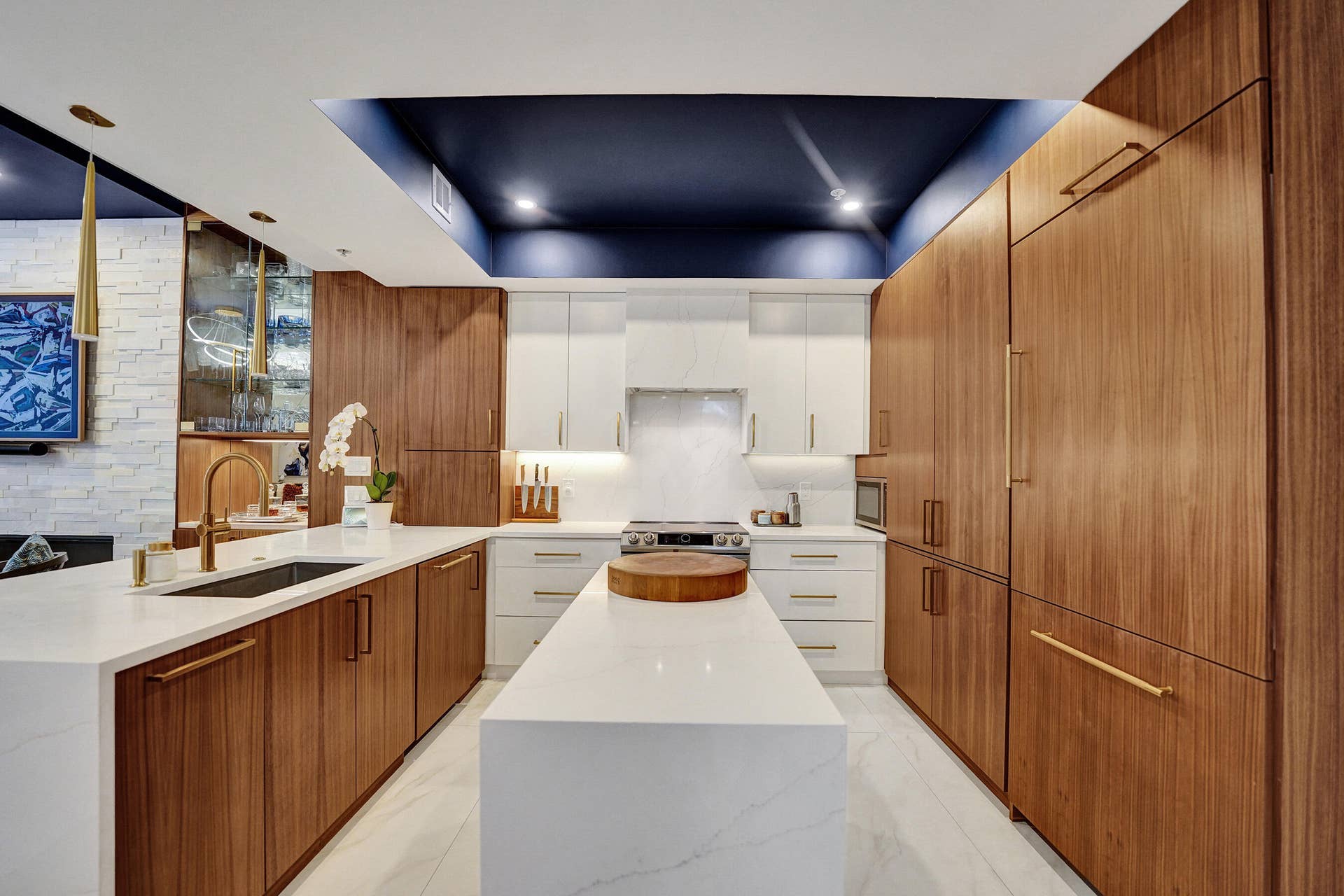 Contemporary kitchen featuring wood-finish cabinetry, white countertops, and a central island