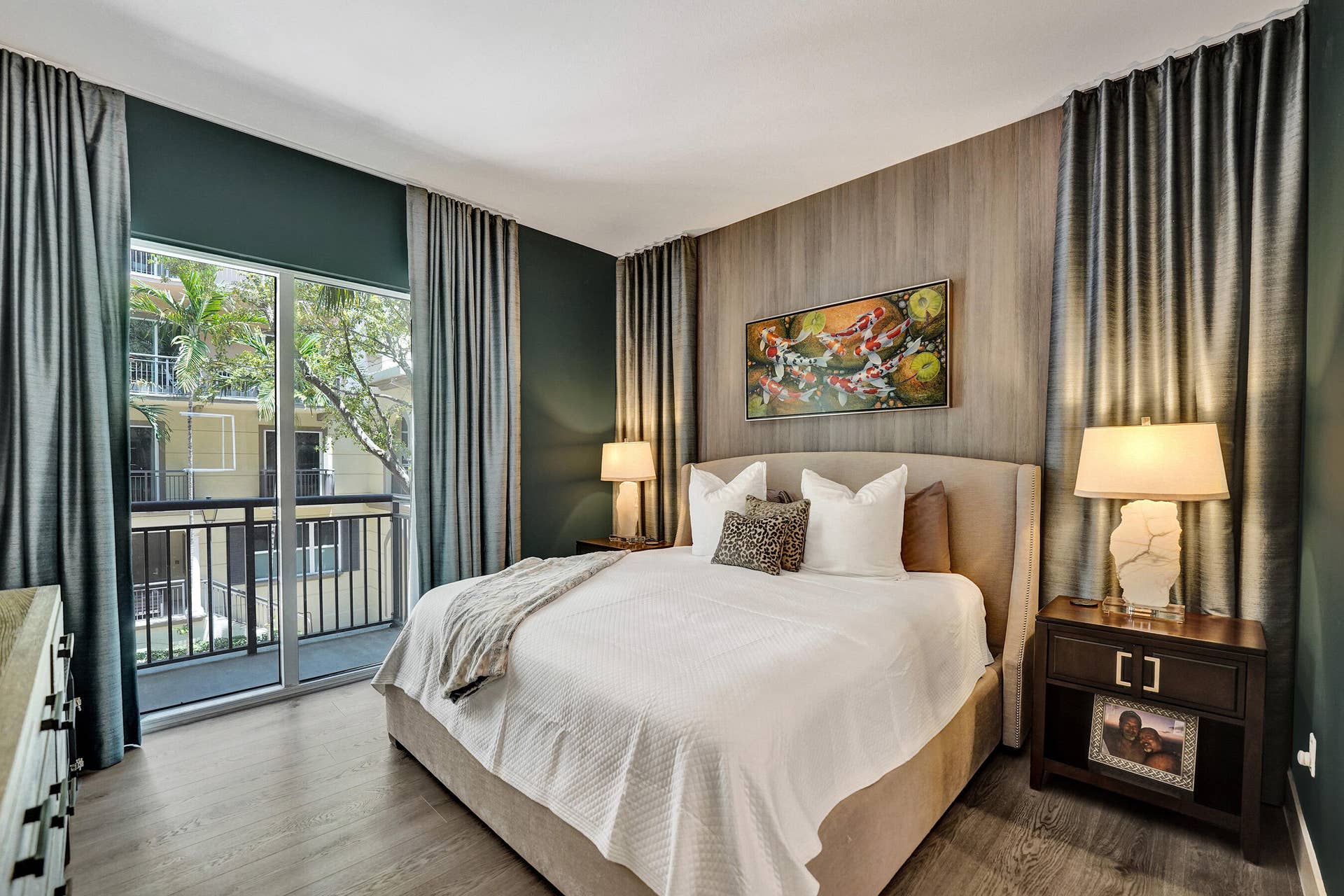 Full-height sliding glass doors with balcony access, wood-finish flooring, and a feature wall with vertical paneling