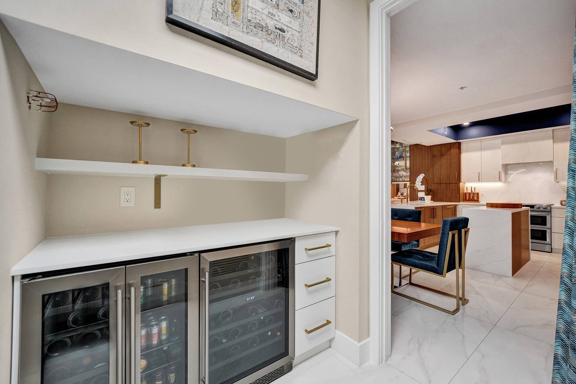 Built-in beverage coolers, white quartz countertop, integrated shelving, and gold-finish hardware