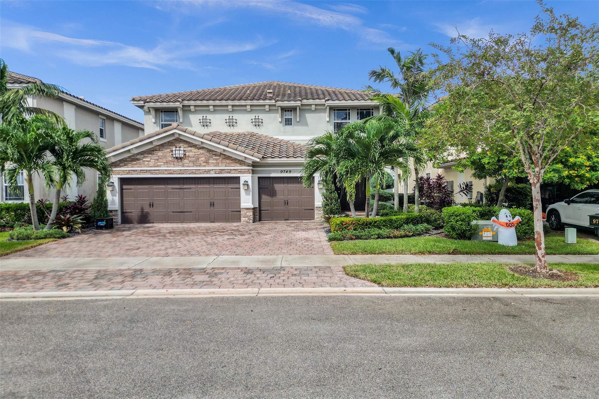 9749 Blue Isle, #BAY, Parkland, FL 33076 Two-story residence featuring a tile roof, stone facade accents, and a paver driveway