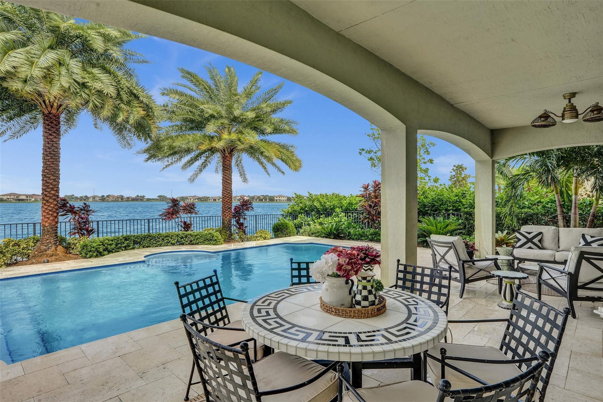 9749 Blue Isle, #BAY, Parkland, FL 33076 Covered patio featuring arched architectural details, outdoor ceiling fan, tile flooring, and a built-in swimming pool
