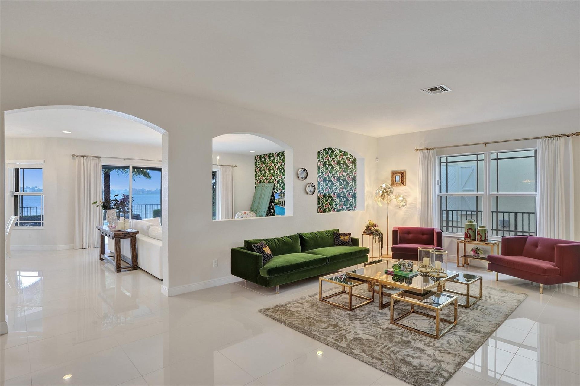 9749 Blue Isle, #BAY, Parkland, FL 33076 Glossy tile flooring, arched doorways, a partial wall opening, and large windows with water scenery