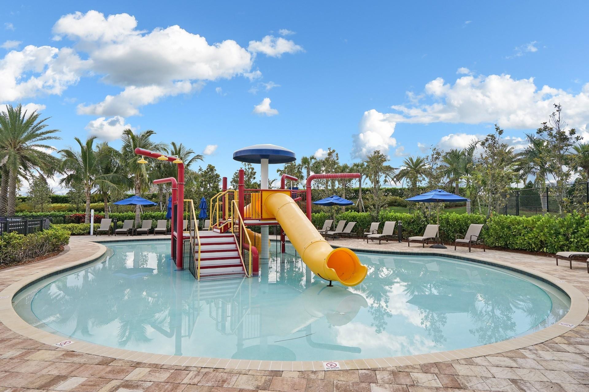 9749 Blue Isle, #BAY, Parkland, FL 33076 Resort-style pool with a children's water play structure, surrounding paver decking, and lush tropical landscaping