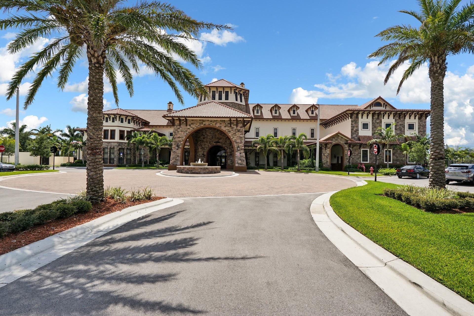 9749 Blue Isle, #BAY, Parkland, FL 33076 Stone facade with arched entryway, central fountain, and dormer windows