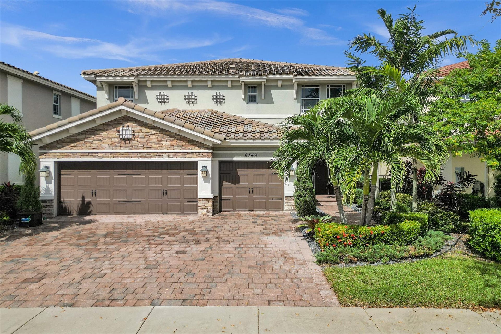 9749 Blue Isle, #BAY, Parkland, FL 33076 Two-story stucco and stone facade, tile roof, dual garage doors, paver driveway, and mature landscaping