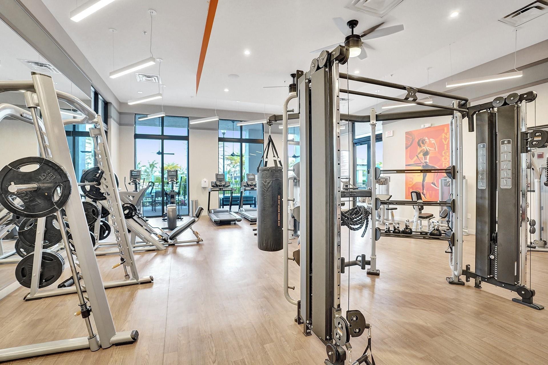9749 Blue Isle, #BAY, Parkland, FL 33076 Spacious fitness area featuring wood-finish flooring, floor-to-ceiling windows, and multiple exercise machines