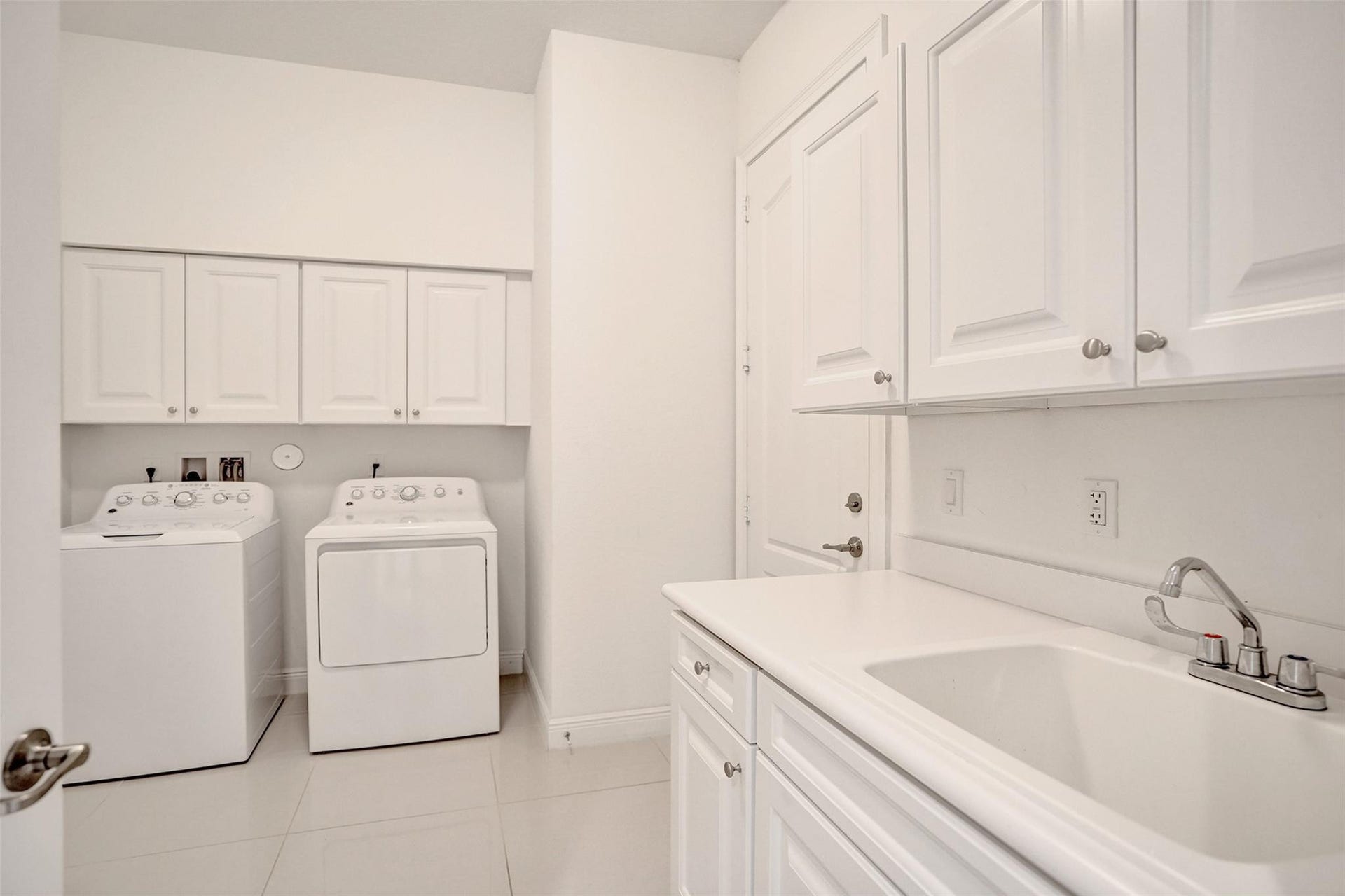 9749 Blue Isle, #BAY, Parkland, FL 33076 Laundry area featuring white cabinetry, a utility sink, and white tile flooring