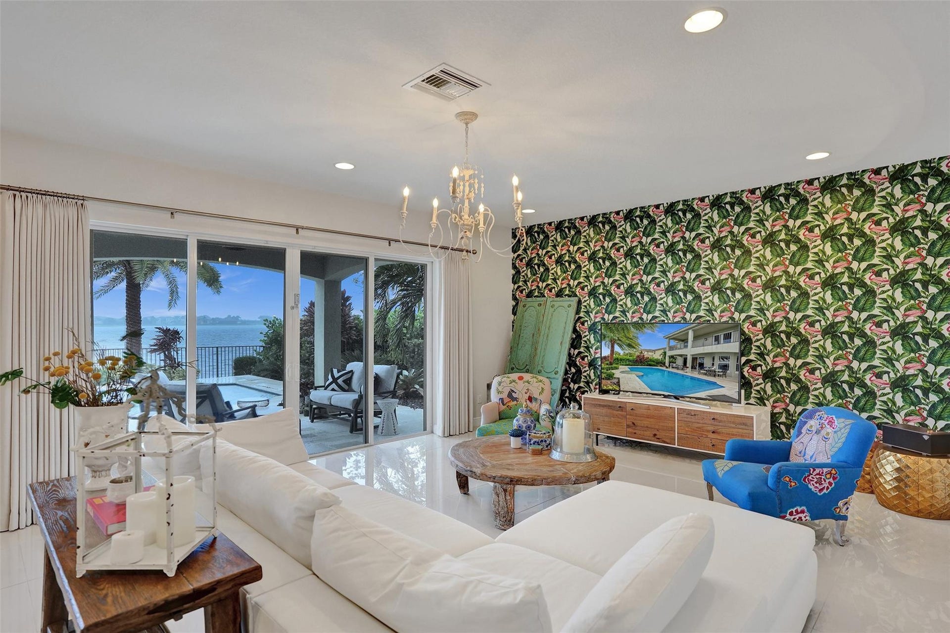 9749 Blue Isle, #BAY, Parkland, FL 33076 Sliding glass doors opening to a covered patio, recessed lighting, chandelier, and a decorative accent wall
