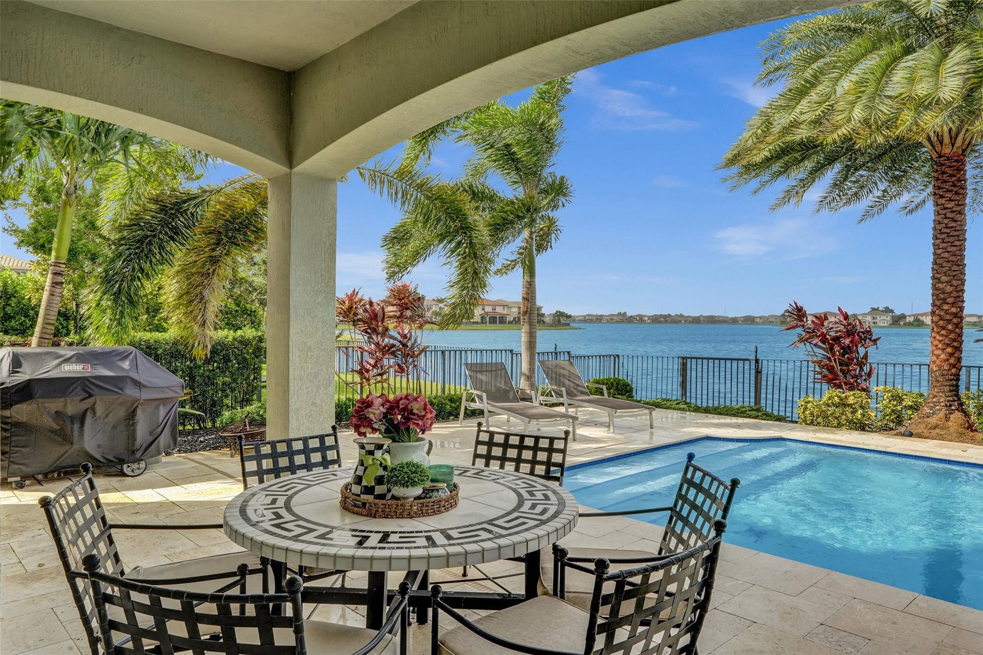 9749 Blue Isle, #BAY, Parkland, FL 33076 Covered patio with a tile floor, an in-ground pool, and a metal fence bordering the water