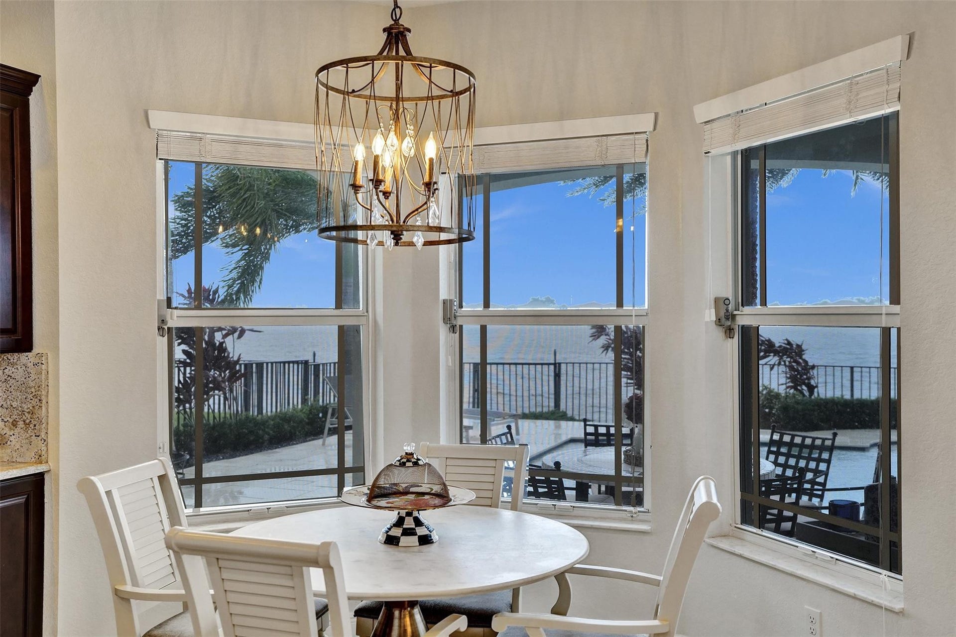 9749 Blue Isle, #BAY, Parkland, FL 33076 Bay windows with expansive water scenery, pool deck, and a contemporary chandelier