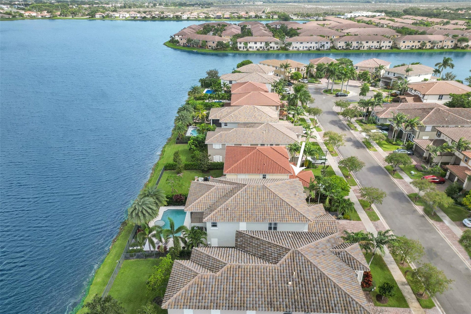 9749 Blue Isle, #BAY, Parkland, FL 33076 Waterfront property with a terracotta tile roof, private swimming pool, and mature landscaping