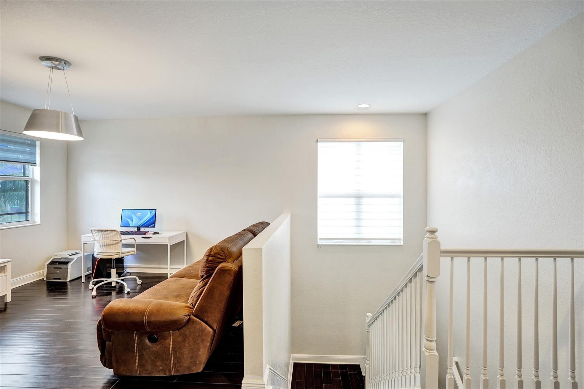 9749 Blue Isle, #BAY, Parkland, FL 33076 Rich wood-finish flooring, white walls, and a contemporary pendant light fixture