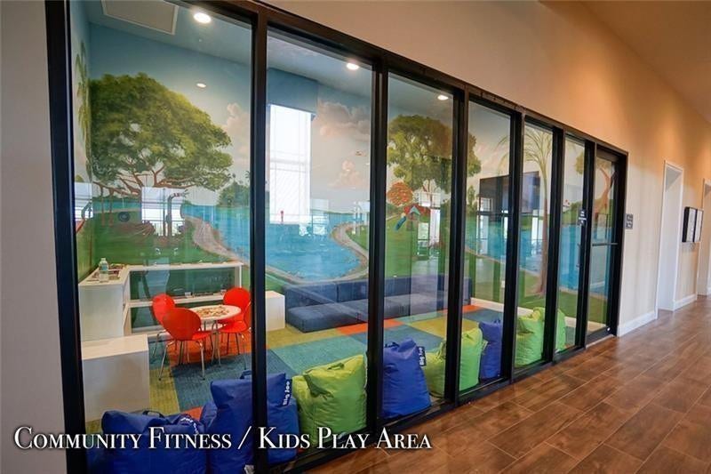 9749 Blue Isle, #BAY, Parkland, FL 33076 Dedicated play area with vibrant wall murals, expansive glass partitioning, and recessed lighting