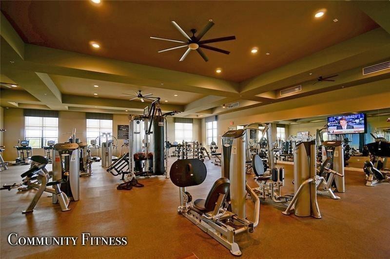 9749 Blue Isle, #BAY, Parkland, FL 33076 Spacious fitness area featuring ample natural light, numerous exercise machines, a wall-mounted television, and ceiling fans