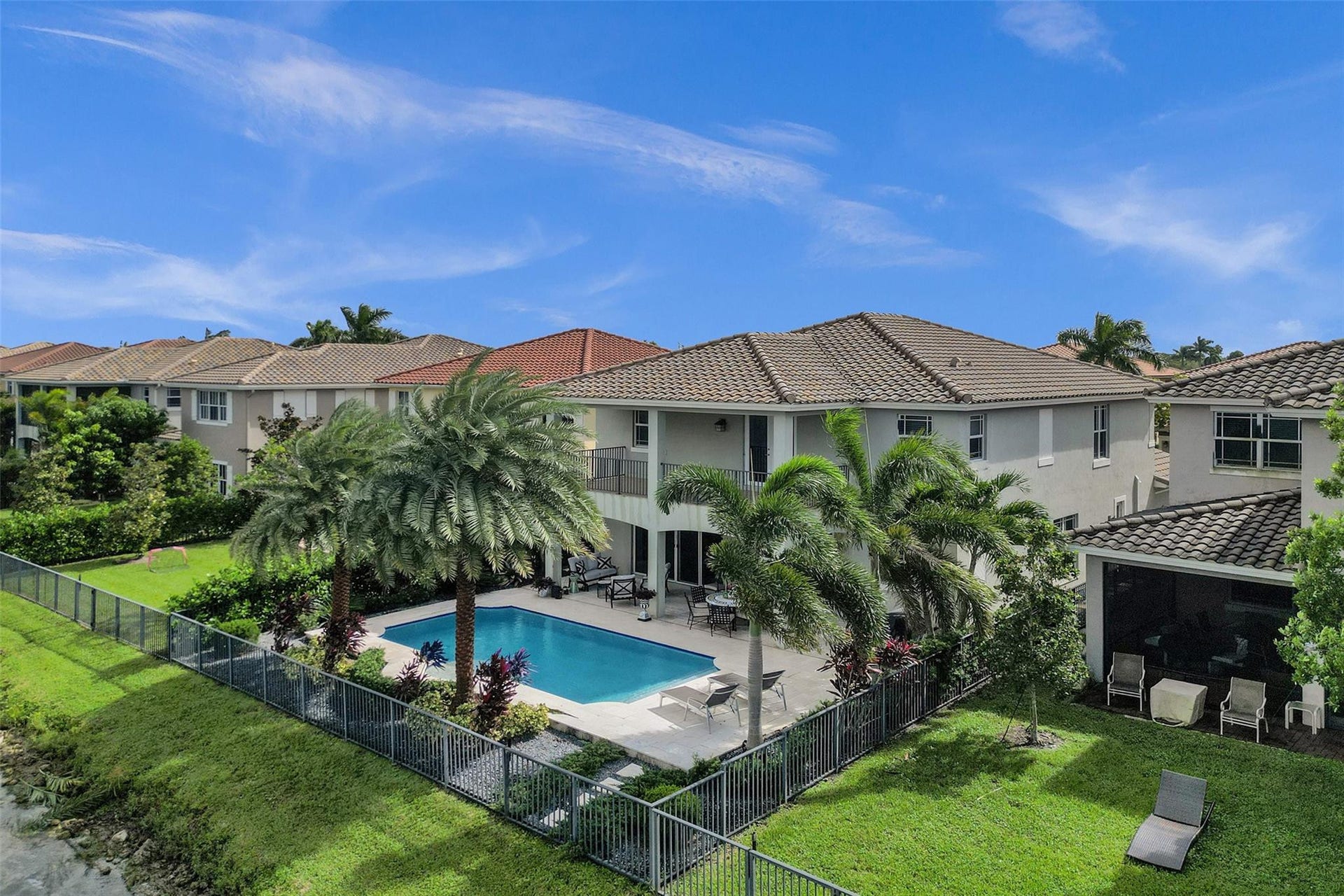 9749 Blue Isle, #BAY, Parkland, FL 33076 Two-story stucco exterior with a tiled roof, private swimming pool, and a fenced backyard with established landscaping