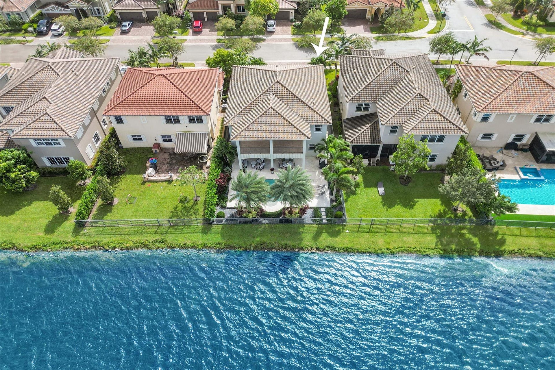 9749 Blue Isle, #BAY, Parkland, FL 33076 Waterfront property with a covered patio, swimming pool, and mature landscaping