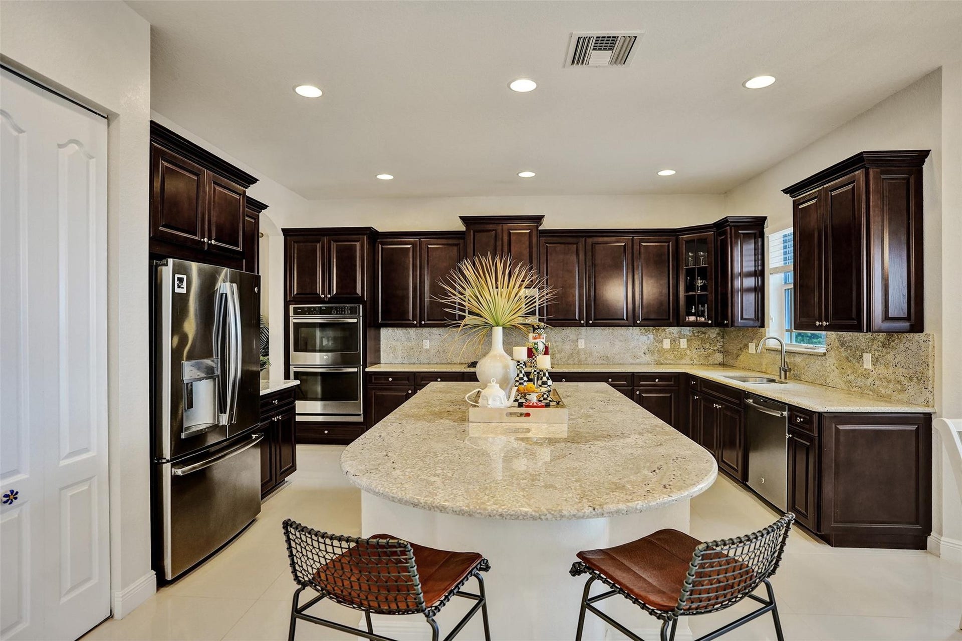 9749 Blue Isle, #BAY, Parkland, FL 33076 Kitchen featuring dark wood cabinetry, light-toned countertops, stainless steel appliances, a center island, and recessed lighting