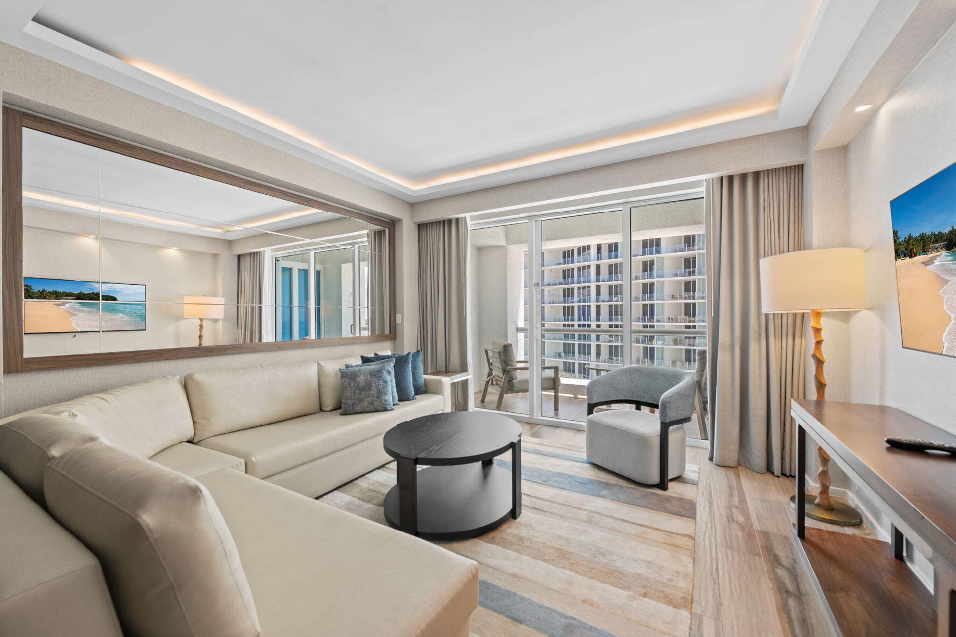551 N FORT LAUDERDALE BEACH Boulevard, #H1011, Fort Lauderdale, FL 33304 Expansive living space featuring a full-wall mirror, wood-finish flooring, and recessed ceiling lighting