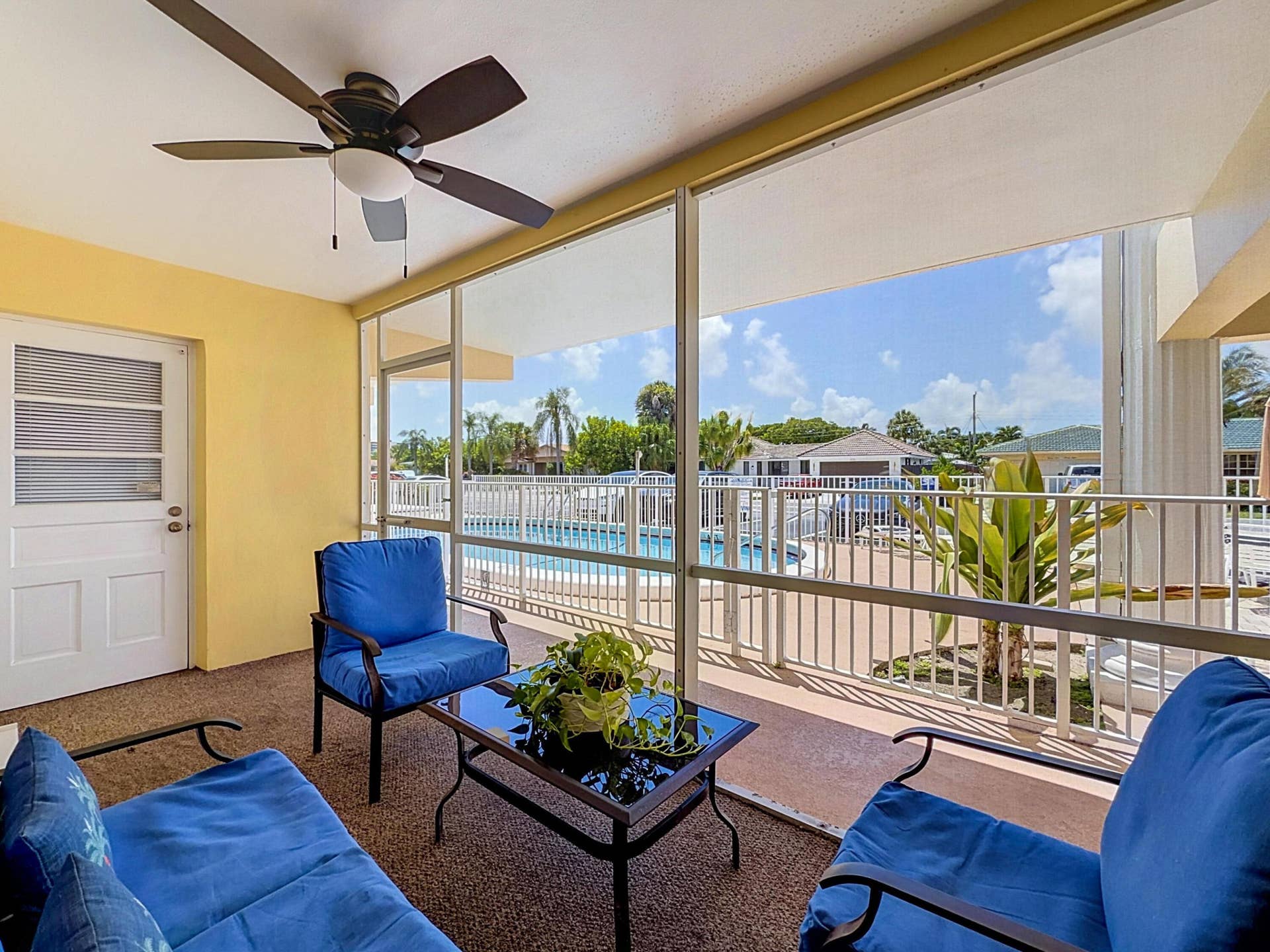 Screened-in patio with a ceiling fan and textured flooring