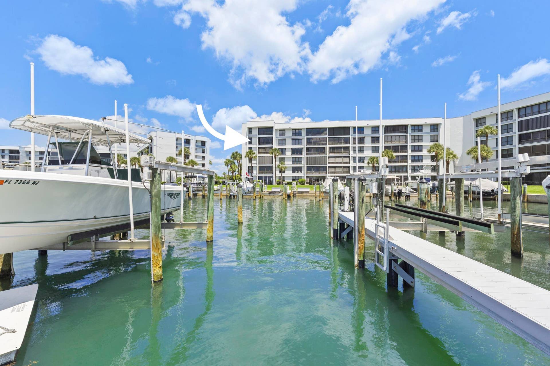 Waterfront property featuring a multi-story building, boat docks, and boat lifts