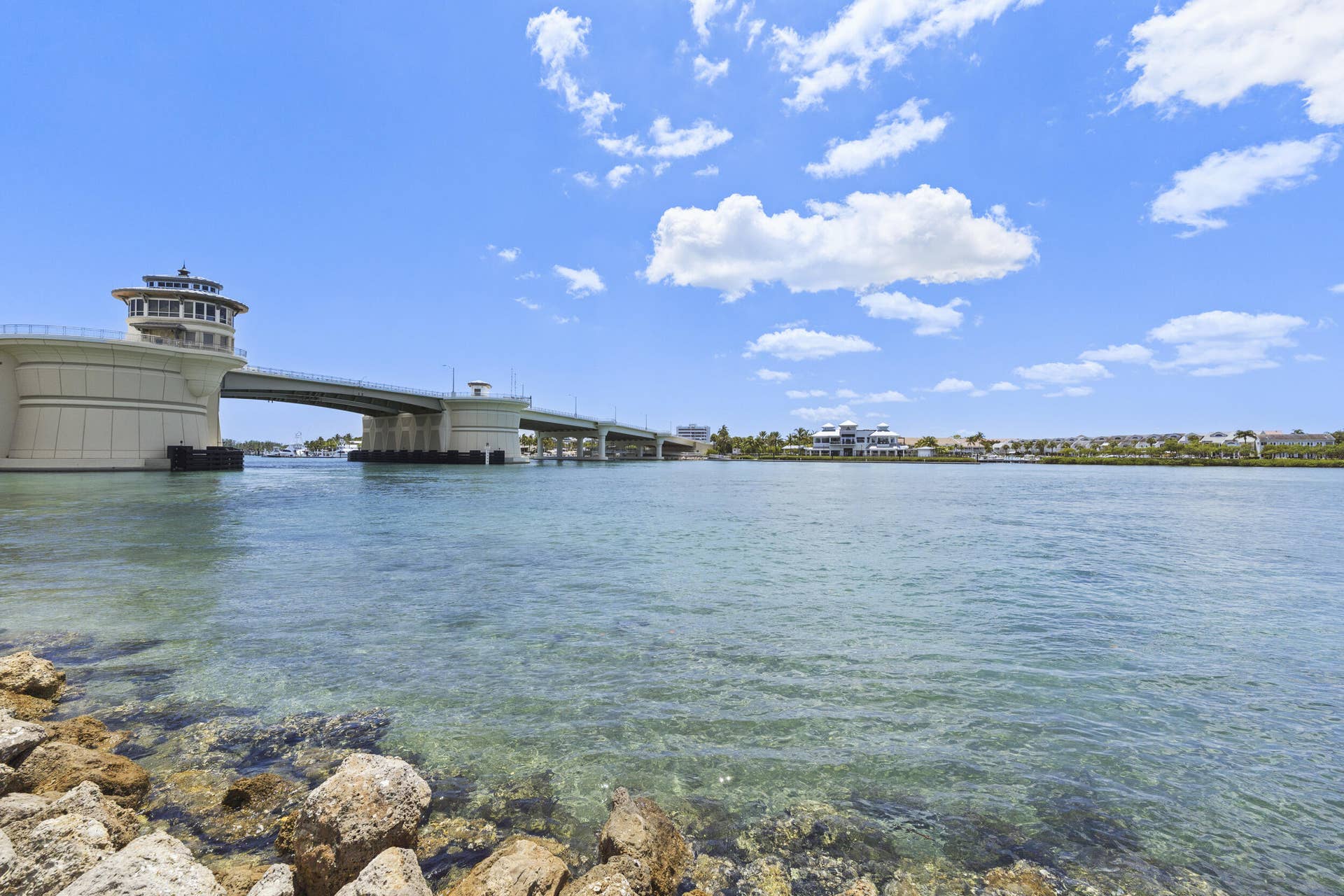 Waterfront property with a bridge, a waterway, and a distant shoreline with structures