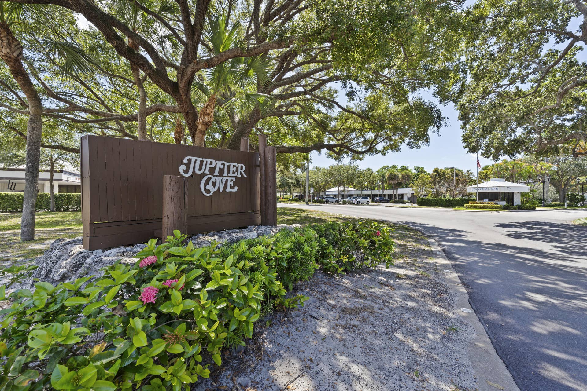 Entryway signage featuring wood-finish details and lush landscaping