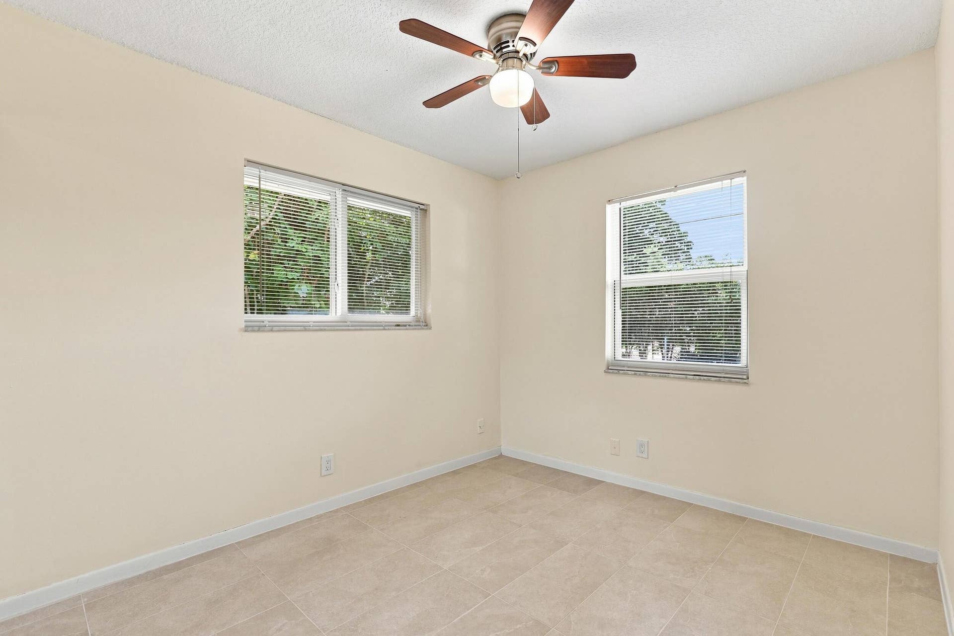 5114 Conklin Drive, Delray Beach, FL 33484 Bright bedroom with ceiling fan, neutral finishes, and multiple windows.