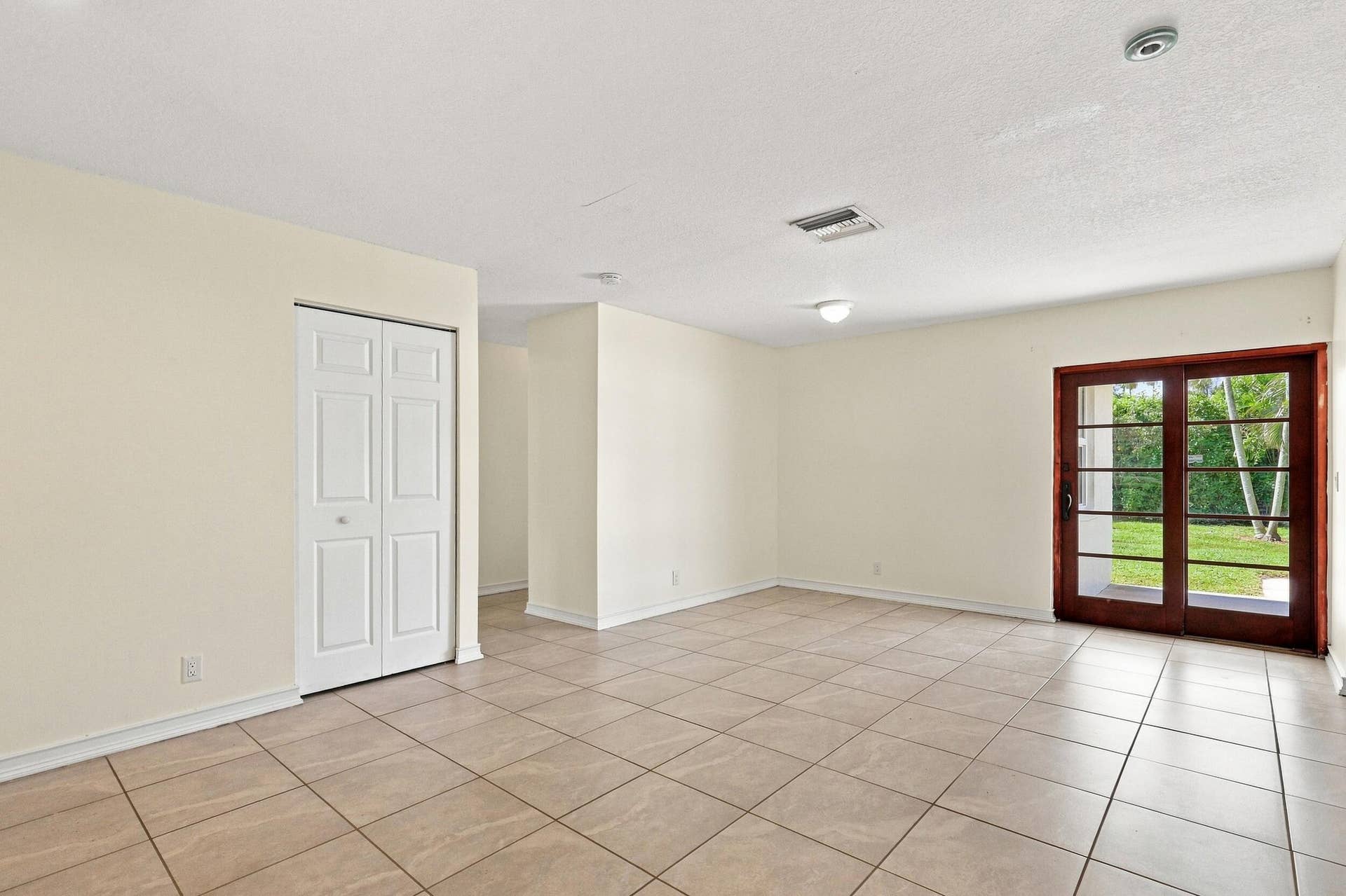 5114 Conklin Drive, Delray Beach, FL 33484 Bright, open living space with tile flooring and French doors providing natural light.