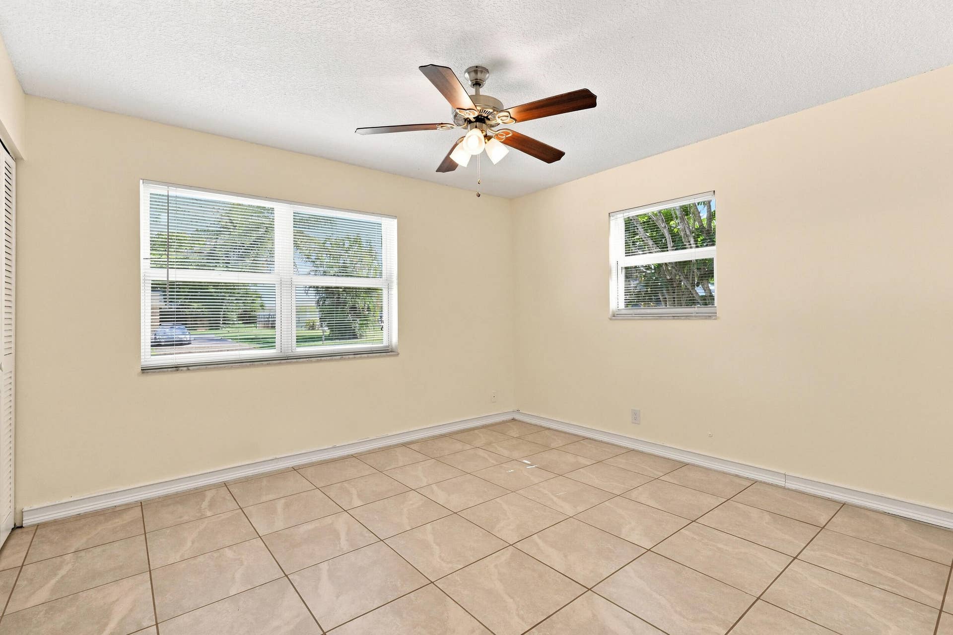 5114 Conklin Drive, Delray Beach, FL 33484 Tiled bedroom with ceiling fan, neutral finishes, and convenient access to the adjoining area.