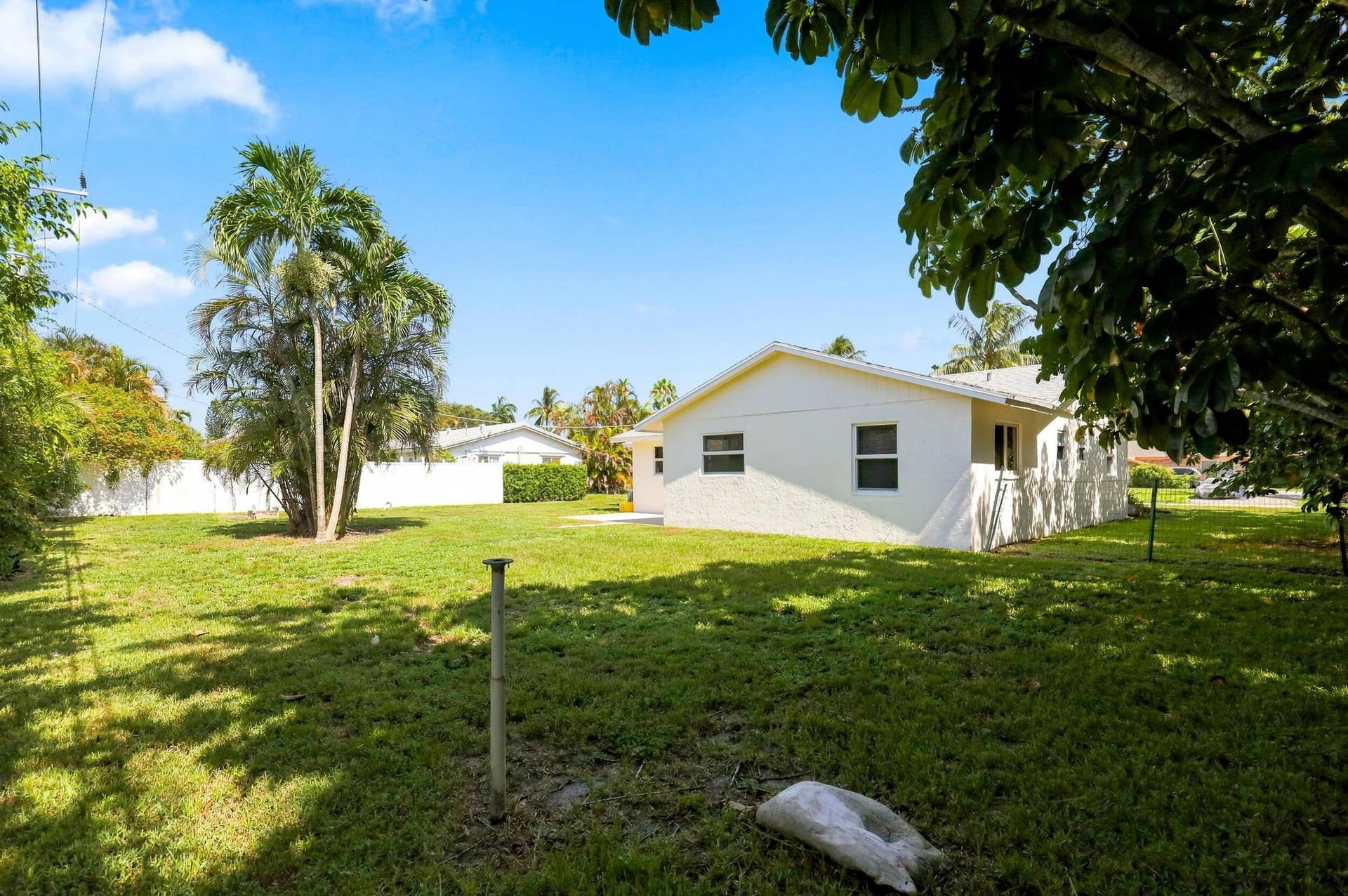 5114 Conklin Drive, Delray Beach, FL 33484 View of the rear of the home featuring a spacious yard and mature trees.