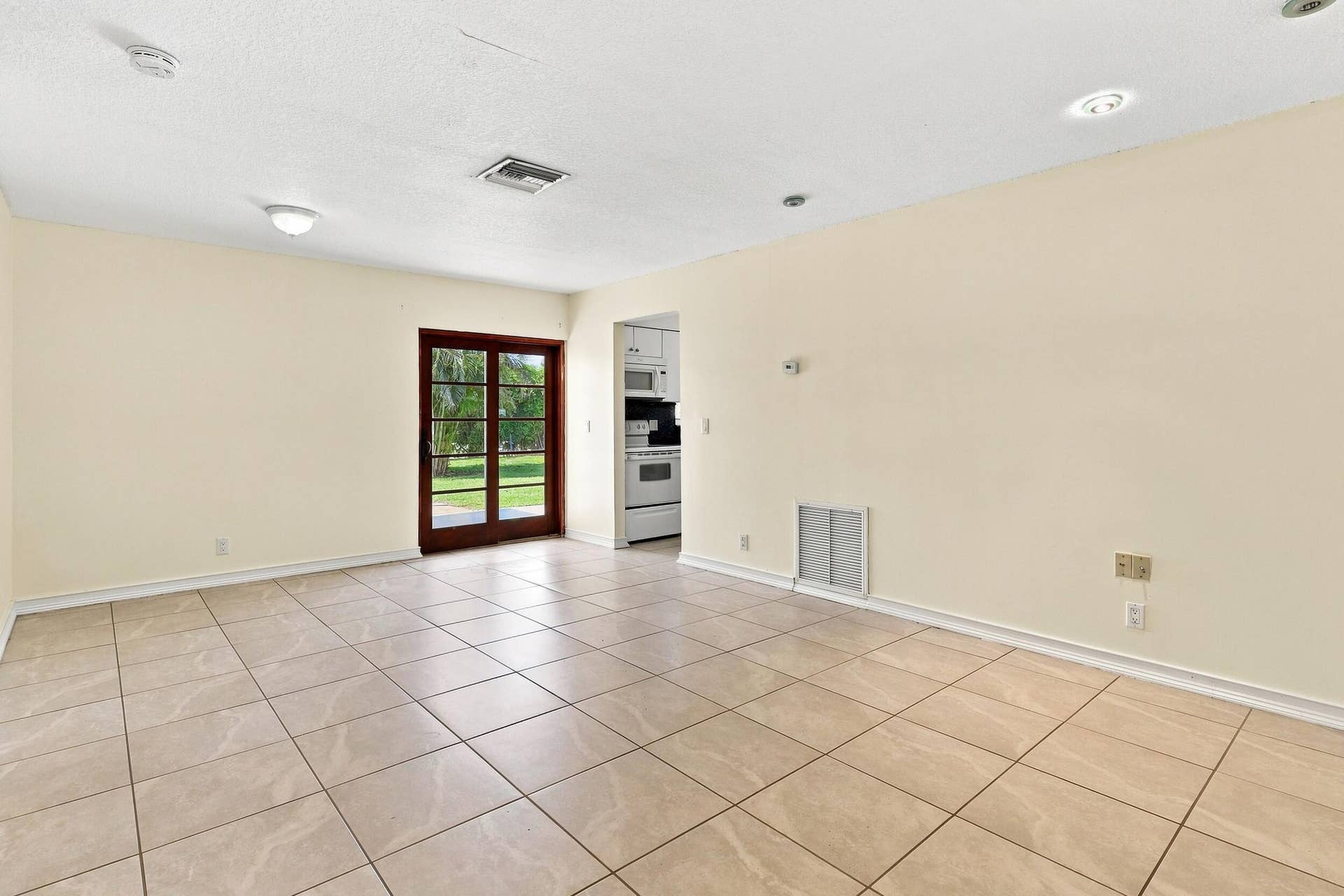 5114 Conklin Drive, Delray Beach, FL 33484 Spacious tiled living area with neutral finishes, recessed lighting, and access to the rear of the home.