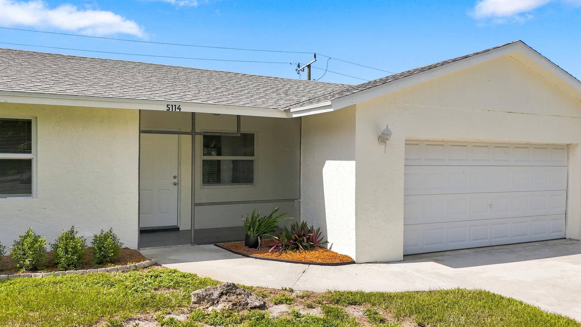 5114 Conklin Drive, Delray Beach, FL 33484 Welcoming front exterior featuring the covered entry and attached garage.