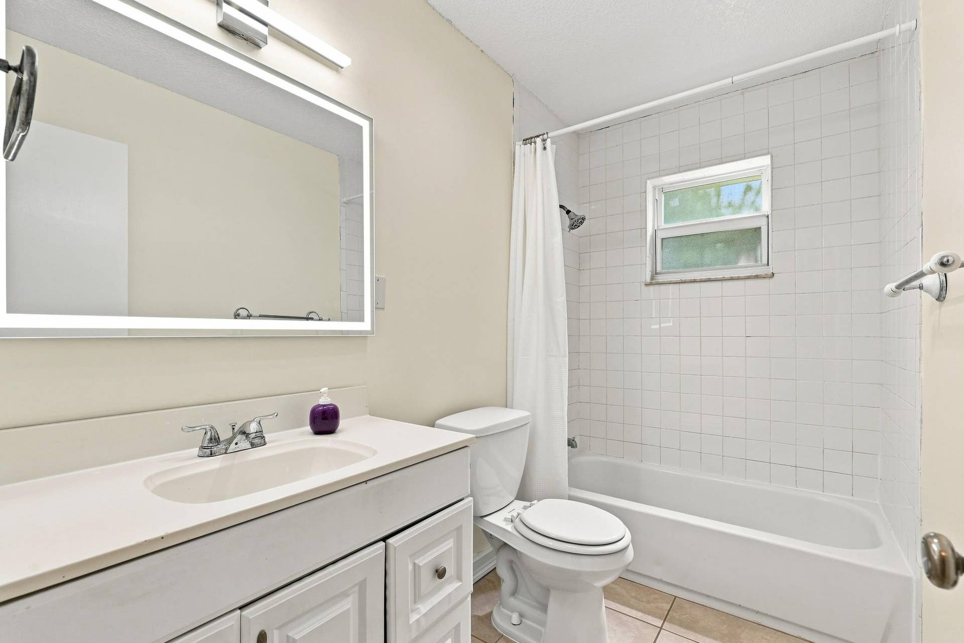 5114 Conklin Drive, Delray Beach, FL 33484 Additional bathroom view highlighting the vanity, tub and shower, and natural light.