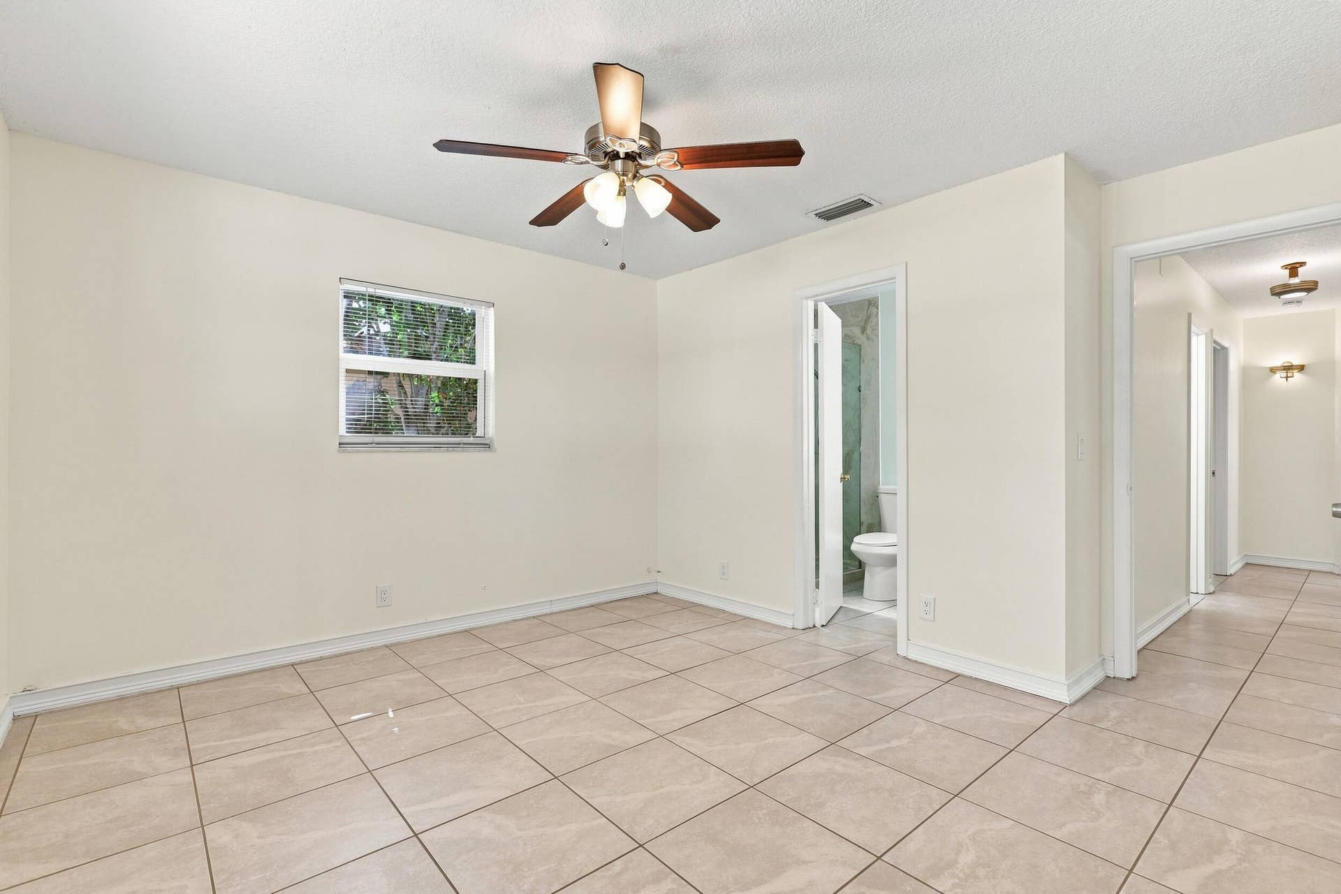5114 Conklin Drive, Delray Beach, FL 33484 Bright bedroom with tile flooring, ceiling fan, and natural light.