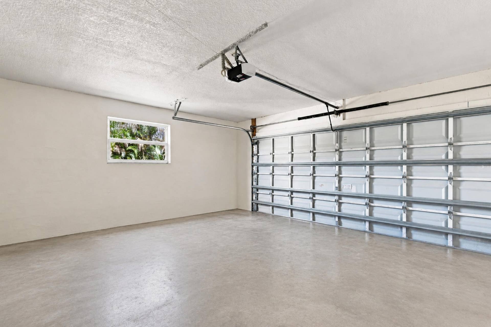 5114 Conklin Drive, Delray Beach, FL 33484 Attached garage with finished walls, overhead garage door, and additional storage space.