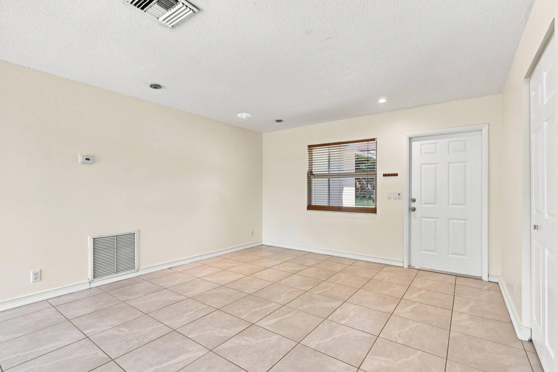 5114 Conklin Drive, Delray Beach, FL 33484 Tiled living space with neutral finishes, recessed lighting, and natural light.