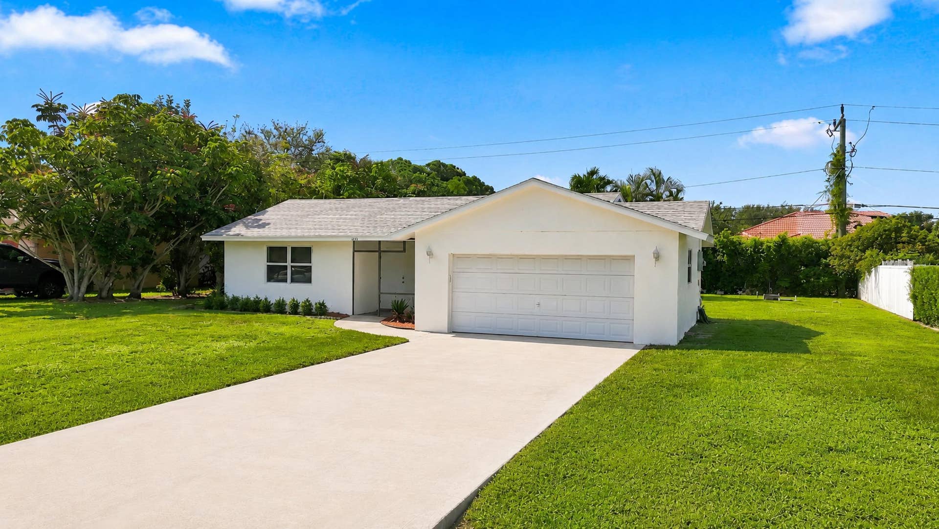 5114 Conklin Drive, Delray Beach, FL 33484 Alternate exterior view showing the driveway, front yard, and home entrance.