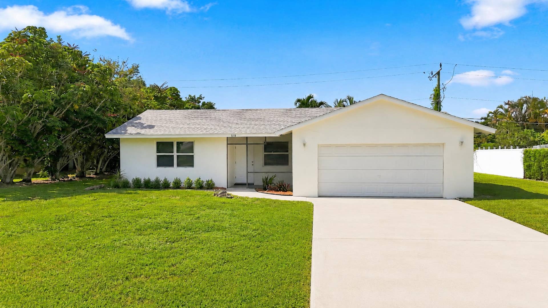 5114 Conklin Drive, Delray Beach, FL 33484 Front view of the home with attached garage, driveway, and lawn.